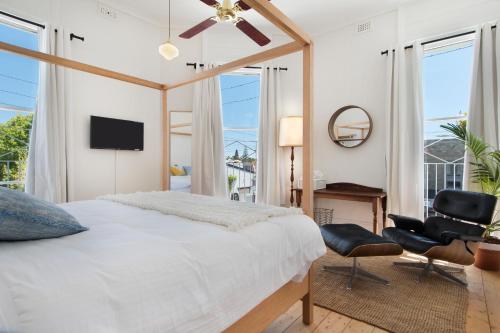 a bedroom with a bed and a chair and a television at The Local Hotel in Fremantle