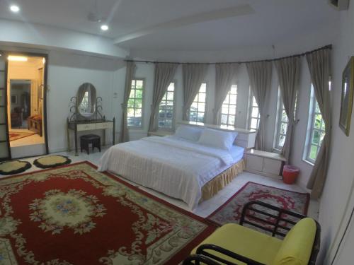 Schlafzimmer mit einem Bett, einem Tisch und Stühlen in der Unterkunft Casa Impiana in Kuantan
