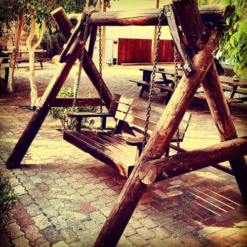 a wooden swing sitting on top of a patio at Arava Hostel in Eilat