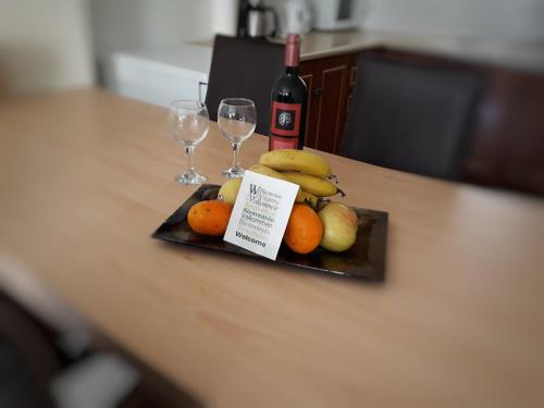 um prato de frutas e dois copos de vinho numa mesa em Old town apartment em Lerápetra