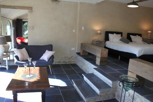 a room with a bed and a couch and a table at Logies Tommenmolen in Grimbergen