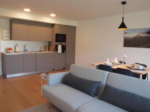 a living room with a couch and a kitchen at Mendialdea Amaiur Baztán in Maya del Baztán