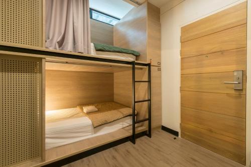 ein Zimmer mit Etagenbett und 2 Etagenbetten. in der Unterkunft T Hostel @ Victory Monument in Bangkok