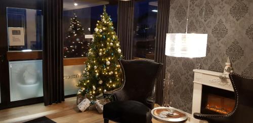 Pension Gockels-Auszeit في باد فيلدونجين: شجرة عيد الميلاد في غرفة معيشة مع موقد