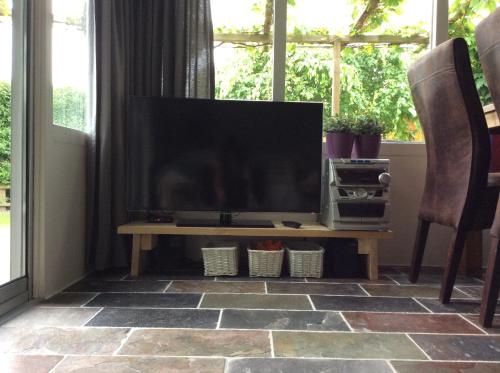 a flat screen tv sitting on a table in a living room at Paradise in Dirkshorn