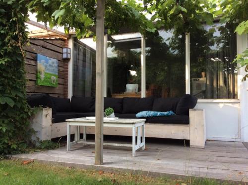 a couch and a coffee table on a patio at Paradise in Dirkshorn