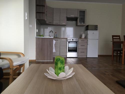 a kitchen with a table with a flower decoration on it at Apartament SunSet in Gdynia