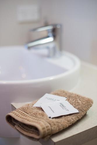 a bathroom sink with a towel with a note on it at By the Beach B&B Self Contained Apartments in Sanctuary Point