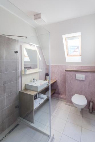 a bathroom with a sink and a toilet at Aurora Vendégház in Hévíz