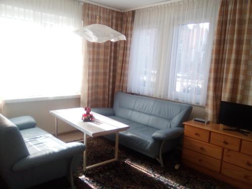 a living room with a blue couch and a table at Ferienwohnung Markert in Blankenburg