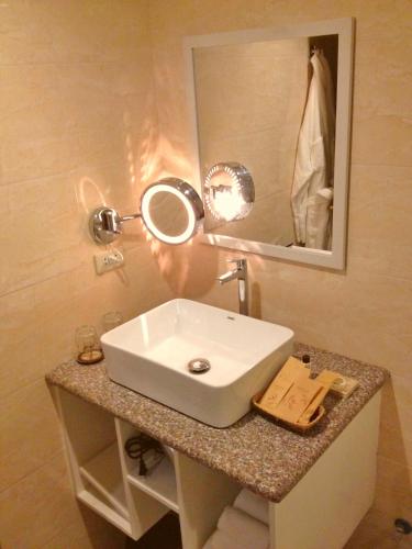 a bathroom with a white sink and a mirror at Skyland Garden Hotel and Resort in Baguio