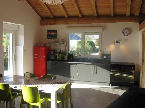 uma cozinha com uma mesa e um frigorífico vermelho em Gîte chez karine et roland em Le Fied