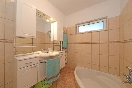 a bathroom with a tub and a sink and a bath tub at Apartments Sanja in Vodice