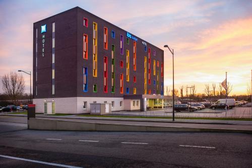 a building with colorful windows in a parking lot at ibis budget Rotterdam The Hague Airport in Rotterdam