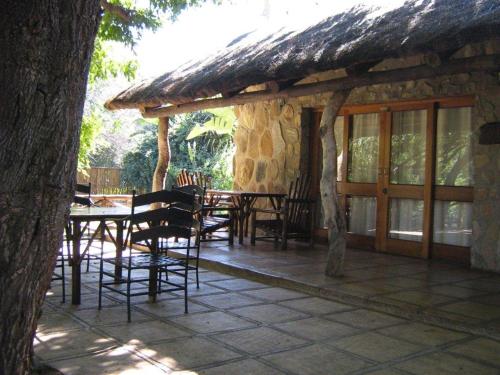 a patio with tables and chairs and a building at Moholoholo Ya Mati in Kampersrus AH