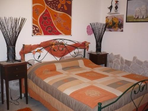 a bedroom with a bed with two night stands and two vases at L'Isola Felice e Trulli Sotto Le Stelle in Castellana Grotte