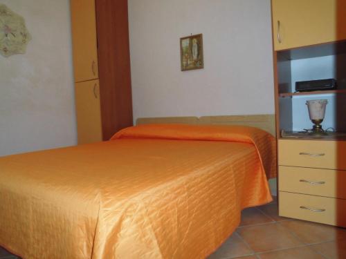 um quarto com uma cama laranja e uma cómoda em Villa bellavista em Castellammare del Golfo