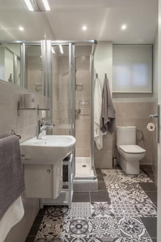 a bathroom with a sink and a shower and a toilet at Atelier Plaza Nueva Plus in Seville