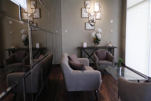 a waiting room with chairs and flowers on the wall at RedDoorz Plus near Universitas Sumatera Utara in Medan