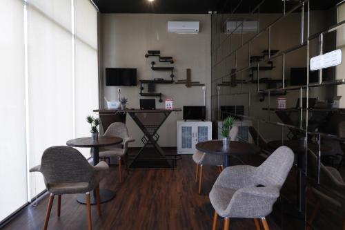 a room with tables and chairs in a room at RedDoorz Plus near Universitas Sumatera Utara in Medan