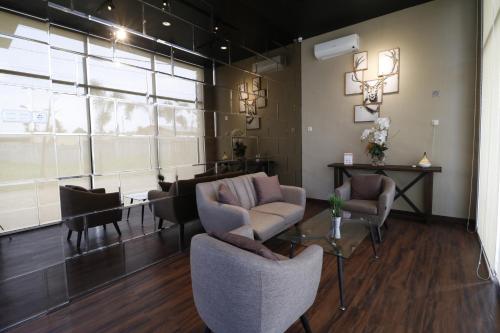 a living room with chairs and a table and a couch at RedDoorz Plus near Universitas Sumatera Utara in Medan