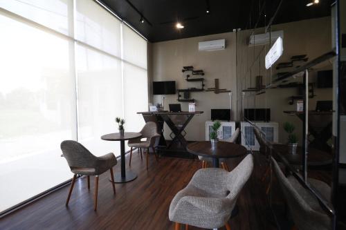 a room with tables and chairs and a large window at RedDoorz Plus near Universitas Sumatera Utara in Medan