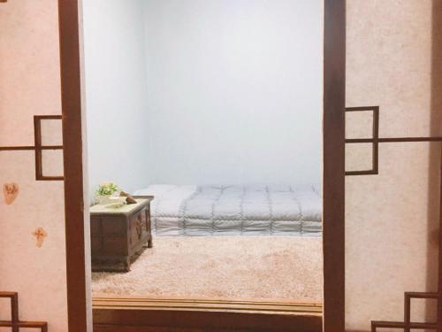 a bedroom with a bed in the corner of a room at ICOS Guesthouse 1 - Female Only in Seoul
