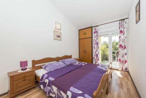 Schlafzimmer mit einem Bett und einem Fenster in der Unterkunft Apartments and Rooms Dragica in Starigrad-Paklenica