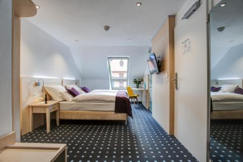 a bedroom with a bed and a tv in a room at Rhein Neckar Hotel in Mannheim