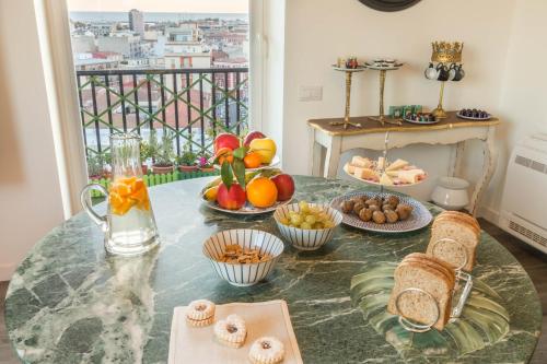 a table with a bunch of fruit and bread on it at Eleventh Floor Suites in Cagliari