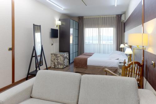 pokój hotelowy z łóżkiem i kanapą w obiekcie Oca Ipanema Hotel w mieście Vigo