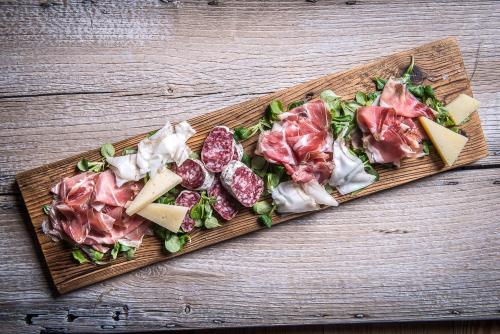 a cutting board with meats and cheese on a table at Berry House in Vigolo Vattaro