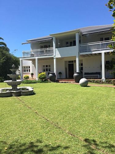 a large white house with a fountain in the yard at Oude Berg Guesthouse - 10 Caledon Street in George