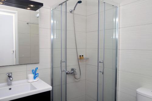 een badkamer met een douche en een wastafel bij Kastellos Apartments Sikinos in Alopronia