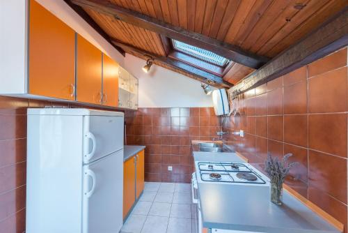 a kitchen with a white refrigerator and a stove at Apartment Lidija in Tisno