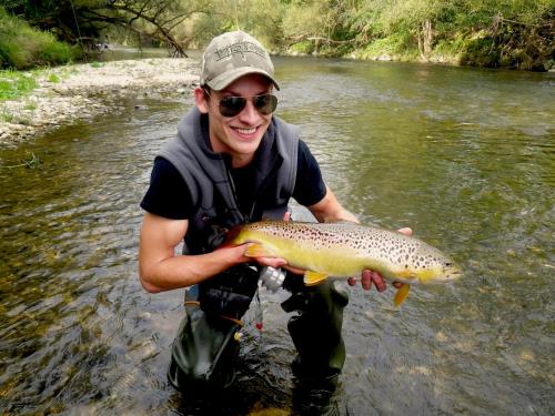 a man in the water holding a brown trout at HOTEL ZILLNERs EINKEHR *** in Altheim