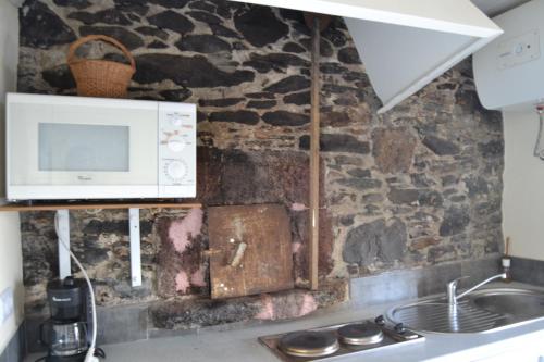 een keuken met een magnetron en een wastafel bij Casal São João Cottages 105 in Fajã da Ovelha