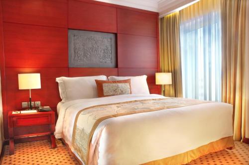 a bedroom with a large bed and a red wall at Hotel Borobudur Jakarta in Jakarta