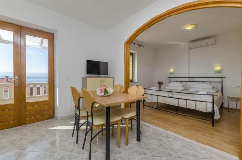 a dining room with a table and a bed at Apartments and Rooms LEA in Bol