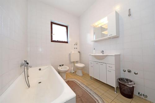 a bathroom with a tub and a toilet and a sink at Rooms Jeriko in Vodice