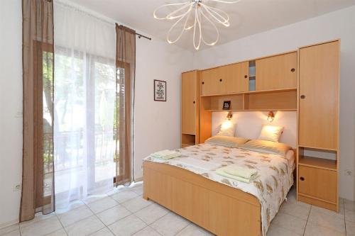 a bedroom with a large bed and a large window at Rooms Jeriko in Vodice