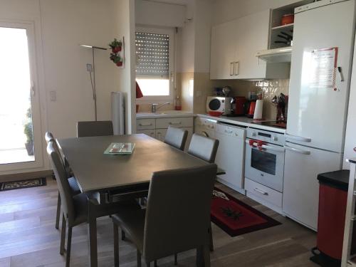 - une cuisine avec une table et des chaises dans la chambre dans l'établissement Appartement, vue mer à 150m de la plage, à Trouville-sur-Mer