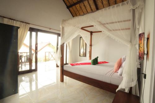a bedroom with a bed with a canopy at Warung Ary & Home Stay in Amed