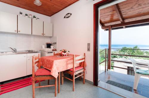 a kitchen with a table and a view of the ocean at Apartments Ilinka in Lovran