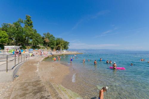 a group of people in the water at a beach at Apartments Ilinka in Lovran