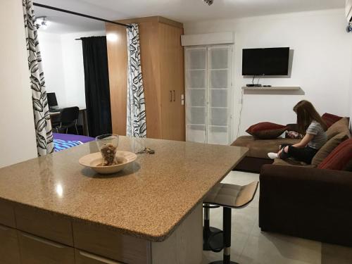 a woman sitting on a couch in a living room at Villa Santo Antonio in Serra do Mouro