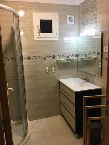 a bathroom with a shower and a sink and a mirror at Villa Santo Antonio in Serra do Mouro