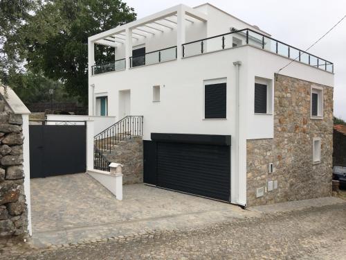 a white house with a gate and a garage at Villa Santo Antonio in Serra do Mouro