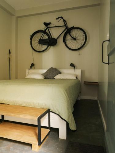 a bike hanging on the wall above a bed at Jungle Soul in Mirissa