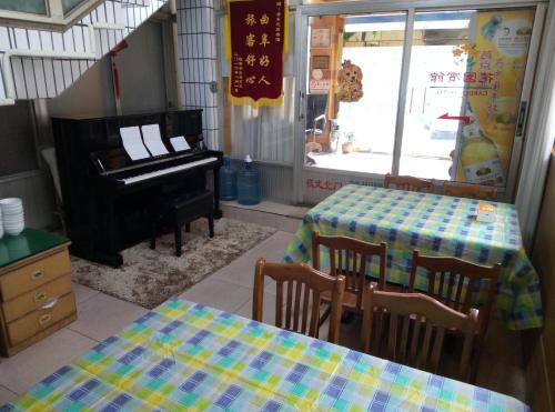 a dining room with a table and a piano at Qufu Garden Hotel in Qufu